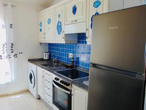 a kitchen with white cabinets and a stainless steel refrigerator at Casita Playa Castillo 5 in Caleta De Fuste