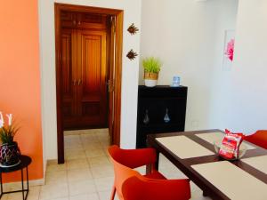 a dining room with a table and red chairs at Casita Playa Castillo 5 in Caleta De Fuste
