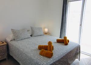 a bedroom with a bed with two teddy bears on it at Casita Playa Castillo 5 in Caleta De Fuste