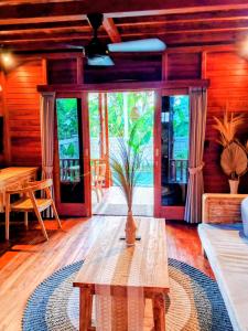a living room with a wooden table with a plant on it at Bene Pertiwi Villa in Ubud