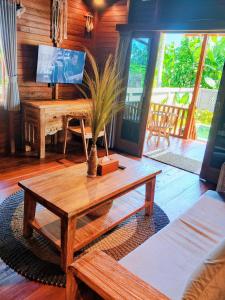 a living room with a coffee table and a tv at Bene Pertiwi Villa in Ubud