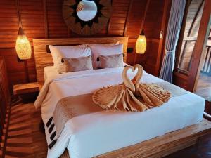 a bedroom with a bed with two swans on it at Bene Pertiwi Villa in Ubud +11 photos