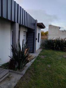 a house with a garage and a grass yard at Moru in Mar del Tuyú