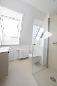 a bathroom with a toilet and a window at Lønstrup Apartments, Havtorn in Lønstrup