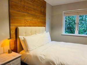a bedroom with a white bed with a wooden headboard at The Black Barn At Puketitiri in Puketitiri +19 photos