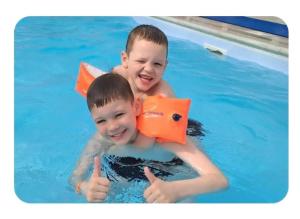 two young boys in a swimming pool giving thumbs up at 5 Minutes Walk From Beach , Fully Disabled,Pet Friendly Caravan With Hot Tub On Coastfields Holiday Village in Skegness
