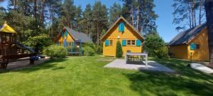 a yard with three small houses and a playground at Nartówka in Narty