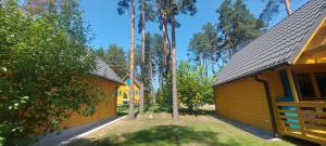 a couple of buildings with trees in a yard at Nartówka in Narty +13 photos