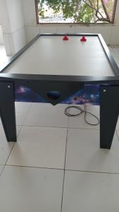a ping pong table with two ping pong paddles on the floor at Flat studio monte castelo gravatá PE in Bezerros