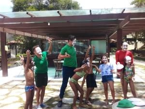 a group of people standing in a yard with their hands in the air at Flat studio monte castelo gravatá PE in Bezerros