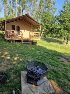 a log cabin with a grill in front of it at Deer Barn Retreats in Hockworthy