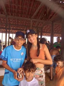 a woman and two children posing for a picture at Flat studio monte castelo gravatá PE in Bezerros