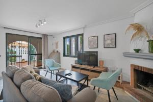 a living room with a couch and a tv at Casa Mar & Golf in San Luis de Sabinillas
