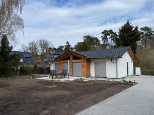 a small house with a garage in a yard at Ferienhaus Senzig Waldesruh in Königs Wusterhausen