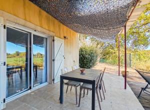 a patio with a table and chairs on a patio at Maison de campagne in Tourrettes