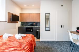 a bedroom with a bed with two white towels at Apex Studios by Derbnb in Derby