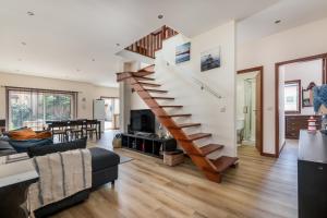 a living room with a staircase in a house at Mindelo Beach House in Vila Chã