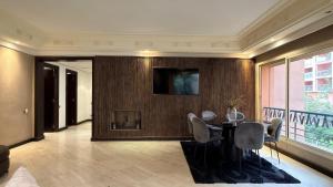 a dining room with a table and a television on a wall at Residence jardin ocre in Marrakesh