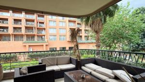 a balcony with a couch and a large building at Residence jardin ocre in Marrakesh