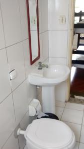 a bathroom with a toilet and a sink at Pousada Vila Pitanga in Santos