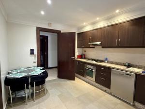 a kitchen with brown cabinets and a table in it at Residence jardin ocre in Marrakesh