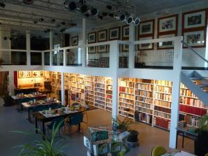a library with tables and chairs and bookshelves at Les chambres noires in Mélisey