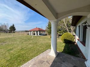 a porch of a house with a field of grass at Siedlisko Studzianki in Studzianki Pancerne