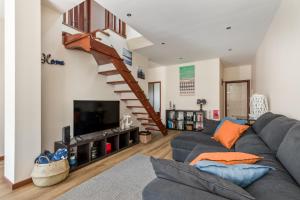 a living room with a couch and a staircase at Mindelo Beach House in Vila Chã
