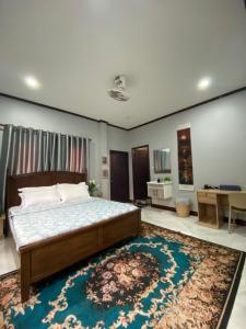 a bedroom with a large bed and a rug at Ban Loom Guesthouse & Weaving Workshop in Luang Prabang