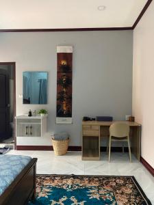 a bedroom with a desk and a table and a chair at Ban Loom Guesthouse & Weaving Workshop in Luang Prabang