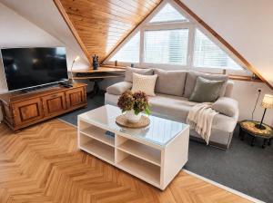 a living room with a couch and a tv at Apartments Poldi in Bled