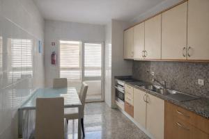a kitchen with a table and a sink and cabinets at City World Apartment in Maia