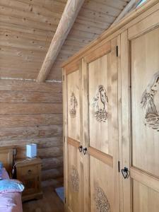 a bedroom with wooden walls with drawings on the doors at Cabanele 2 Mitici in Săliştea de Sus +18 photos
