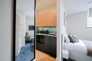 two images of a kitchen and a bedroom with a bed at Apex Studios by Derbnb in Derby