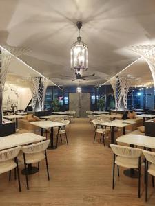 a restaurant with tables and chairs and a chandelier at HF Pool Resorto in Chennai