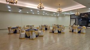 a banquet hall with tables and chairs and chandeliers at HF Pool Resorto in Chennai +196 photos