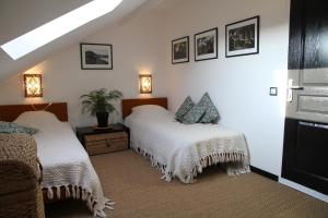 a bedroom with two beds and two lamps on the wall at Les chambres noires in Mélisey