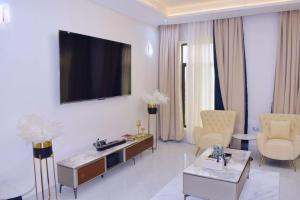 a living room with a tv on a white wall at DDS Homes Apartments in Dodoma