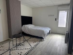 a bedroom with a bed and a table on a rug at Studio in Remiremont