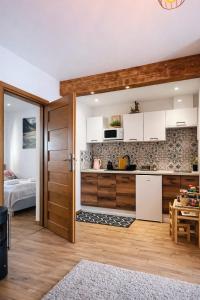 a kitchen with a door open to a bedroom at Apartamenty u Petuski z Jacuzzi in Szaflary