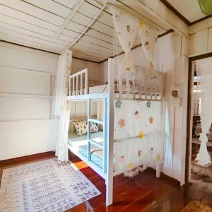 a childs bedroom with a bunk bed and a crib at NiranHouse Hostel in Sathani Phitsanulok