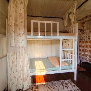 a bunk bed in a room with a curtain at NiranHouse Hostel in Sathani Phitsanulok