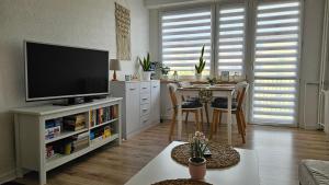 a living room with a television and a table with chairs at DAMS Apartament Oświęcim in Oświęcim