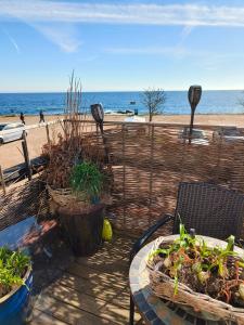 a patio with a table and chairs and the beach at Gruse 9 Svaneke in Svaneke