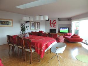 a dining room with a red table and chairs at Gloria's Design House in Santiago de Compostela