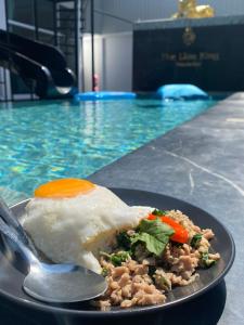 a plate of food on a table in a swimming pool at The Lion King Villa in Ban Na