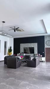a living room with leather couches and a fireplace at The Lion King Villa in Ban Na
