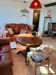 a living room with a table and a leather couch at Gruse 9 Svaneke in Svaneke