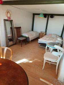 a room with two beds and a table and chairs at Gruse 9 Svaneke in Svaneke