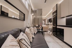 a living room with a black leather couch at Monte Smith Luxury Suites in Rhodes Town
